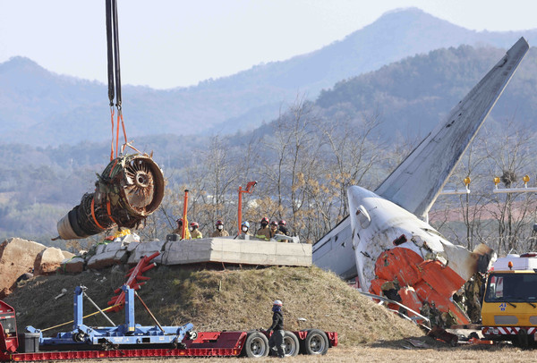 지난 3일 무안군 무안국제공항 제주항공 여객기 참사 현장에서 소방당국 관계자들이 크레인을 이용해 여객기 엔진부분을 들어올리고 있다. /뉴시스