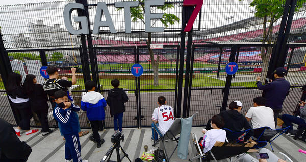 지난 5일 광주-기아챔피언스필드에서 KIA 팬들이 외야석 철조망에 달라붙어 경기를 보고 있다.  			          /뉴시스