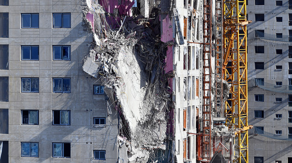 외벽에 매달려 있는 붕괴된 신축 아파트 구조물. /뉴시스