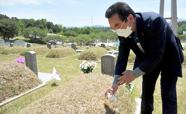 15일 광주 국립5·18민주묘지에서 서삼진(64)씨가 친형인 고 서중진 열사의 묘비에서 참배하고 있다. 							 /뉴시스