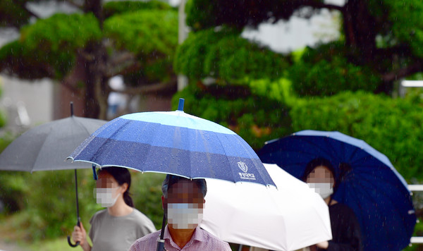 광주 동구 전남대학교병원에서 시민들이 우산을 쓴 채 발걸음을 옮기고 있다. /뉴시스