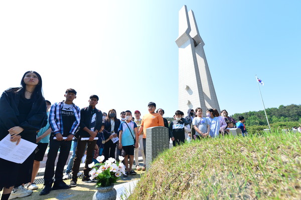 14일 오전 광주 북구 운정동 국립 5·18민주묘지에서 미얀마 이주 노동자들이 희생자의 묘지를 참배하고 있다. 				       /뉴시스