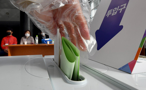 제21대 국회의원 선거 당일인 2020년 4월 15일 오전 광주 북구 용봉동 제4투표소인 전남대 컨벤션홀에서 유권자가 투표함에 투표지를 넣고 있다. /뉴시스