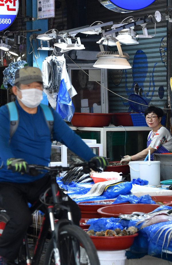 일본 후쿠시마 오염수 방류가 임박한 가운데 광주 동구 학동 남광주수산물시장 상인이 16일 오전 지나치는 시장 방문객을 바라보고 있다.						             /뉴시스